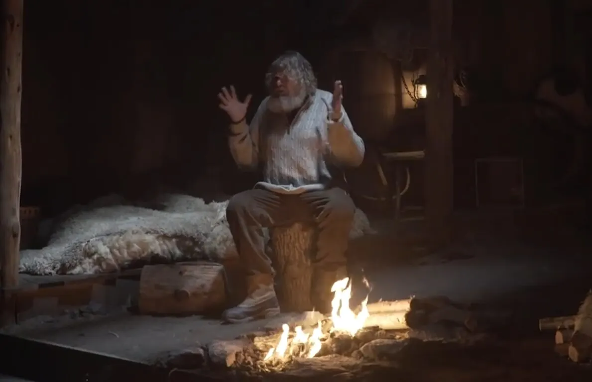 A storyteller by firelight inside the recreated Viking longhouse of the Fly Over Iceland pre-show