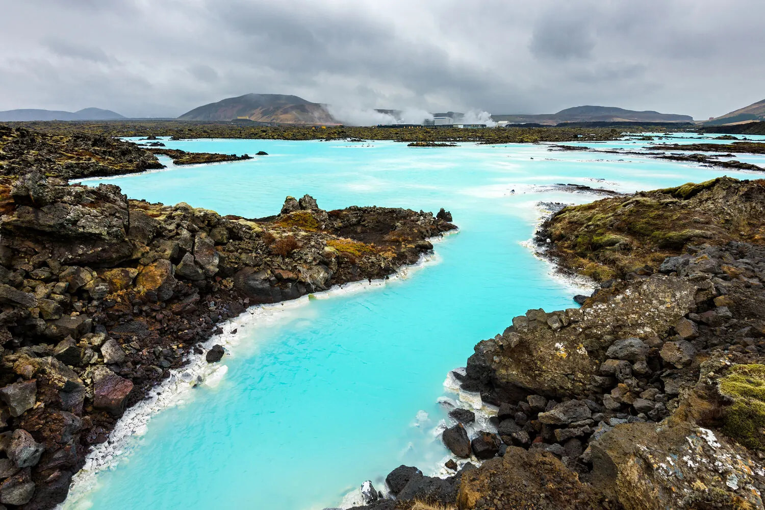 Calm blue lagoon water under a soft Icelandic sky