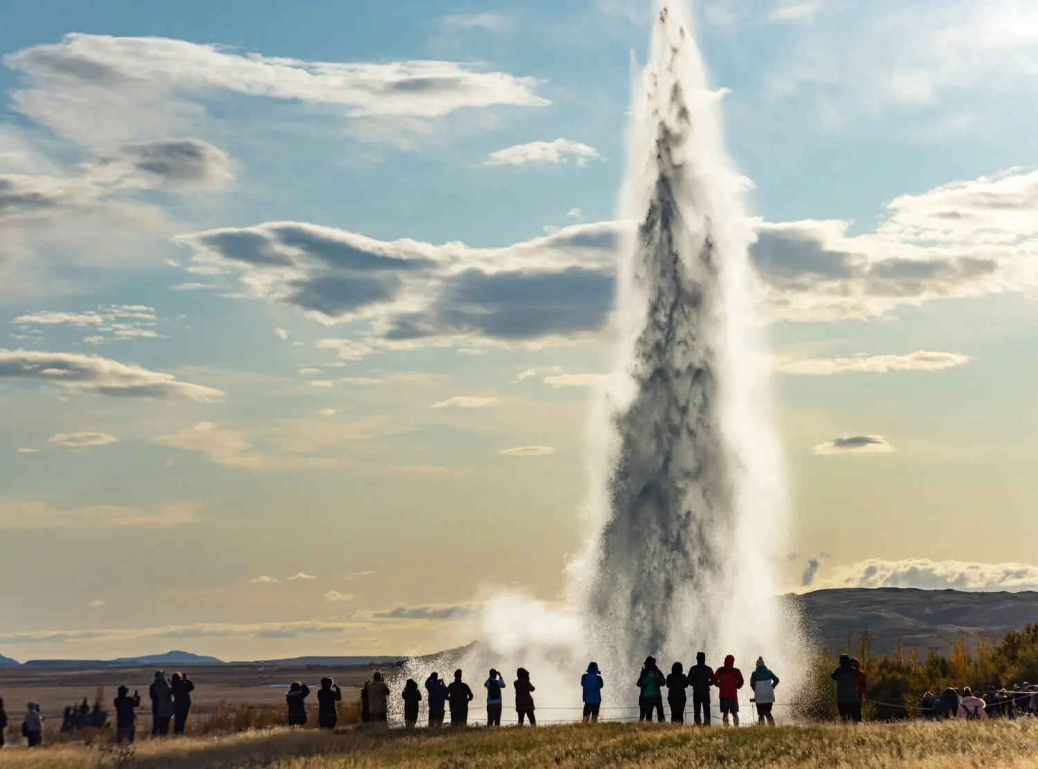 Visitors watching a tall eruption from the Great Geysir geothermal area