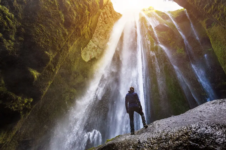 Light streaming down into the narrow mossy gorge that hides Gljúfrabúi waterfall