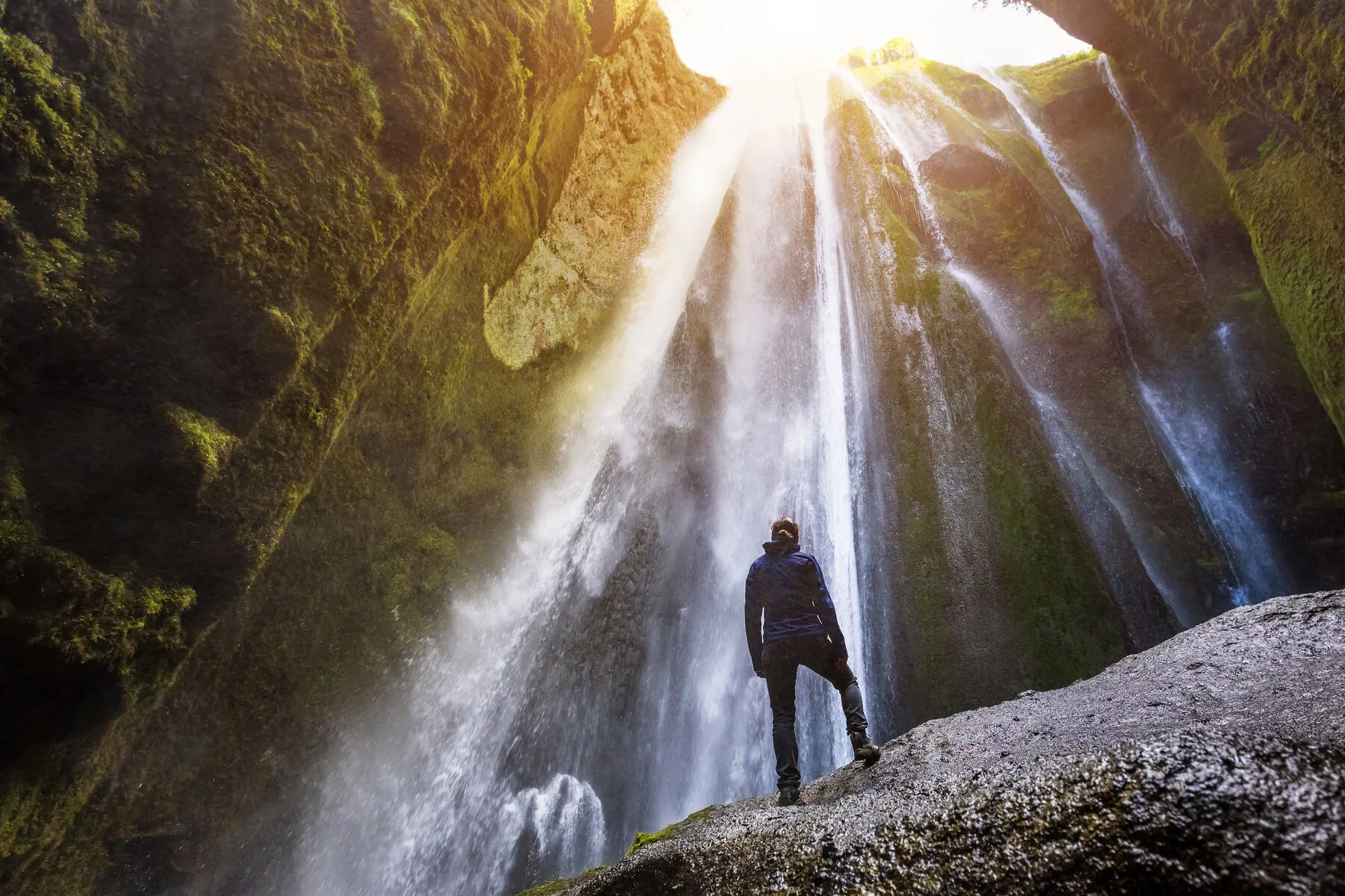 Light streaming down into the narrow mossy gorge that hides Gljúfrabúi waterfall