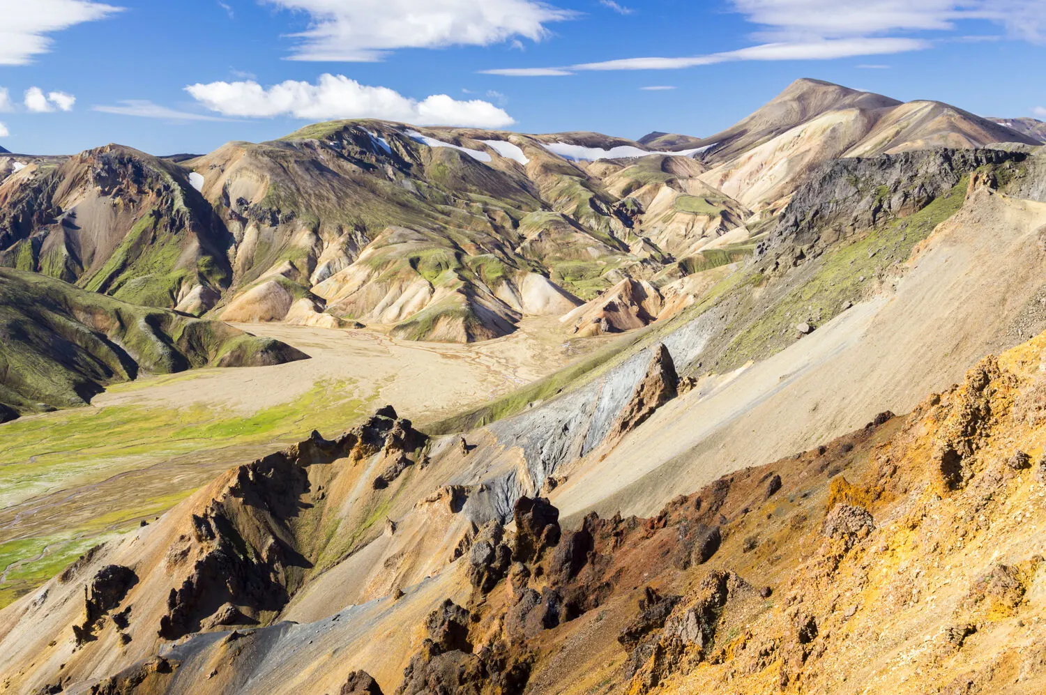 Montagnes de rhyolite colorées, striées de rouille, d’or et de vert à Landmannalaugar, dans les Hautes Terres d’Islande
