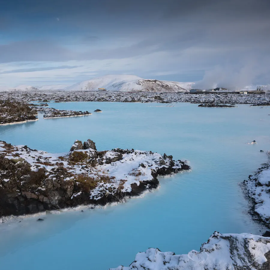 Hot water steaming beside dark volcanic rock